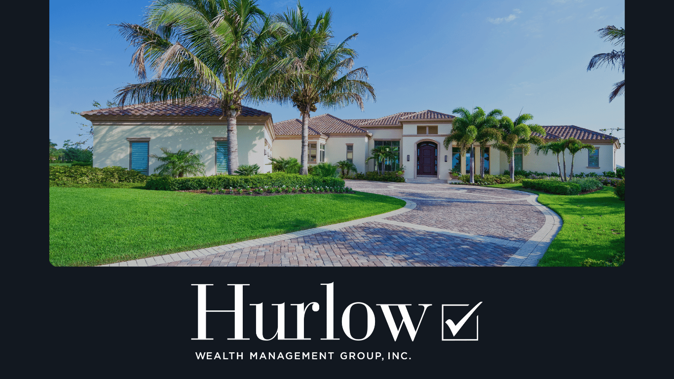A driveway leading to a large house surrounding by palm trees