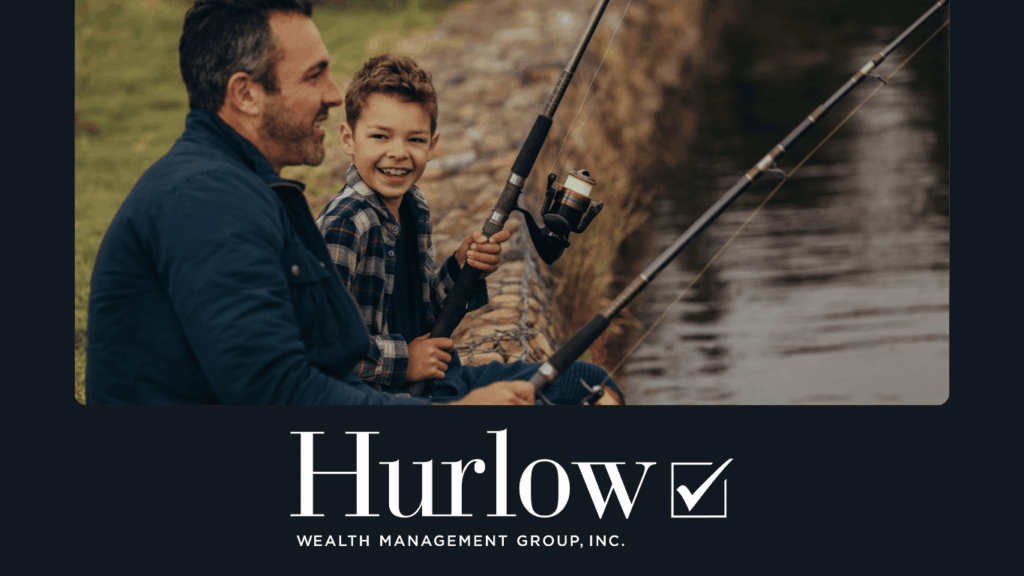 A boy smiles at his father as they fish at a body of water.